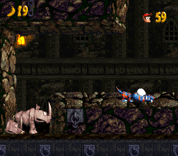 Rambi and the Kongs inside the stone-walled Castle Crush stage in SNES Donkey Kong Country 2.